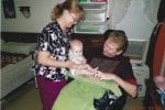 Family Caregiver helping spouse enjoy time with grandchild